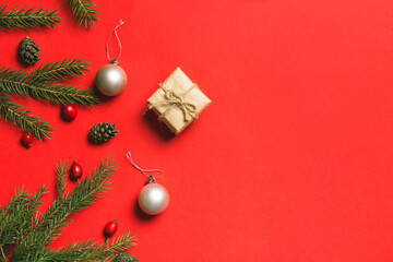 Christmas composition. Frame made of christmas gifts, pine branches, isolated on red background. Flat lay, top view
