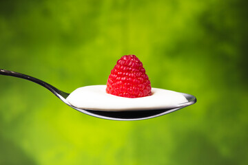 raspberries with cream in a spoon