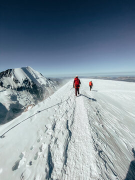 Roped Party descending Mont Blanc under dark blue sky during high wind