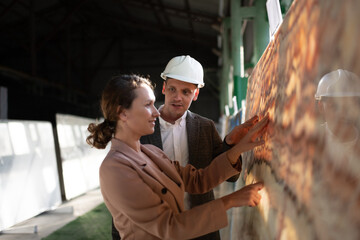 Architect with warehouse manager exploring stone slab