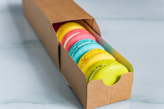 Macaroon Cookies Lie On A White Stone Kitchen Countertop