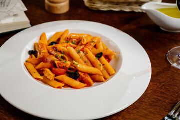 Spaghetti pasta with tomatoes and parsley on wooden table