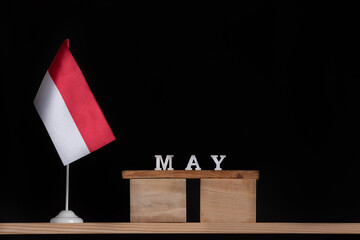 Wooden calendar of May with Polish flag on black background. Holidays of Poland in May .