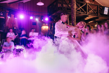 bride and groom dancing at their own wedding in thick smoke
