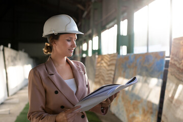 Professional female architect looking through blueprint