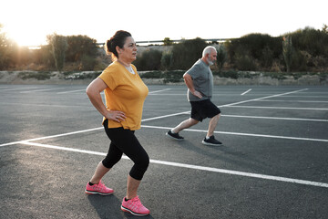 A middle-aged couple are working out on the street