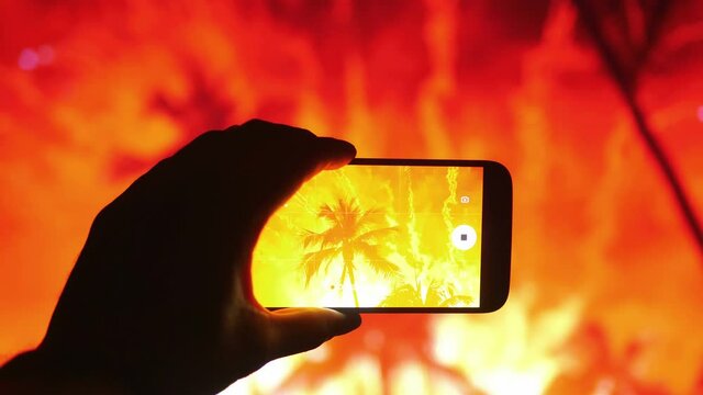 Person taking picture of the fireworks exploding show on tropical island in 4K
