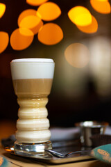 Glass cup with latte on a background of blurry bokeh lights