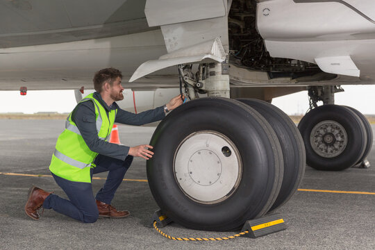 Male mechanic checking aircraft wheels