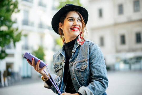 Beautiful woman in autumn dress with hat using cell phone