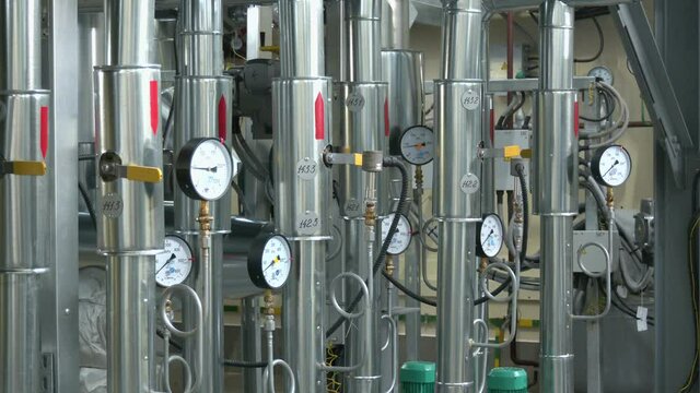 Pumps, pipelines and devices in an interior of modern boiler-house. manometers, pipes and faucet valves of gas heating or water circulation system in a boiler room
