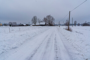 Slippery Countryside Road, Snow Covered Ground on Cloudy Winter Day - Moody Scene