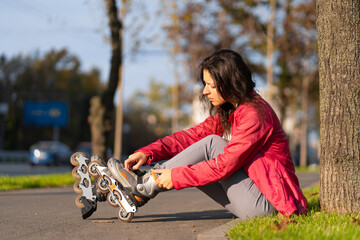 Active leisure. A sportive girl is rollerblading in an autumn park
