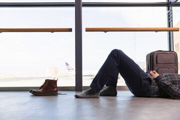 Passenger lying near window in airport