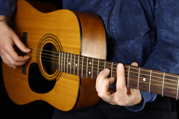 Fototapeta na wymiar man playing acoustic guitar on a black background