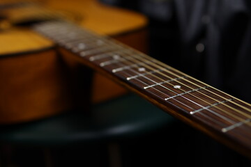 Fototapeta premium Classic wooden acoustic guitar closeup, on a black background, rock, country music concept