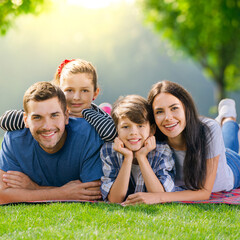 Family at Picnic. Portrait of cheerful smiling young parents and two children, lying at picnic...