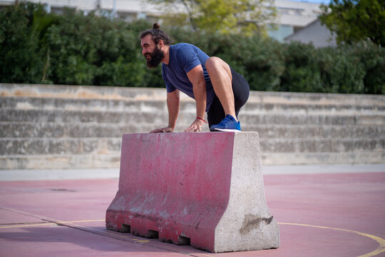 Man trains obstacle race with a platform in the middle of a court