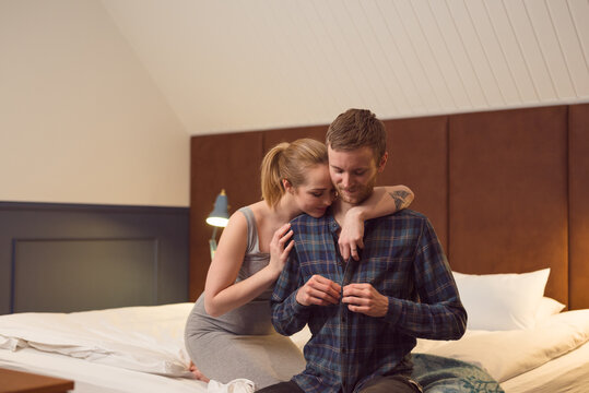 Young couple undressing on bed