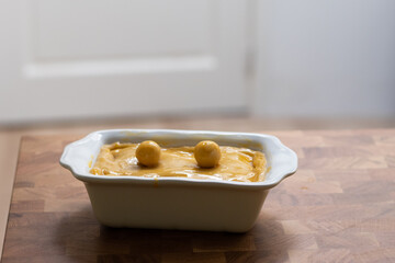 Tart or savory pie in a white dish at wooden table