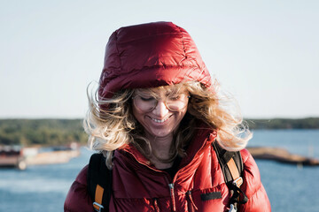 woman stood with her hair blowing in the wind whilst outdoors hiking