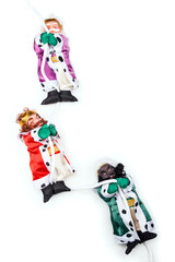 Close up of funny Christmas dolls of three wise men hanging from a rope on a white background with copy space