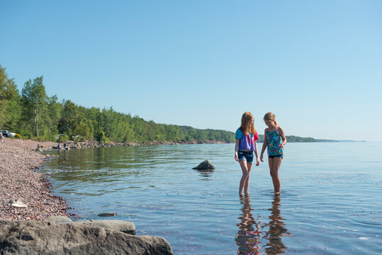 Two Young Girls Exploring Rocky Shoreline