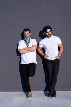 Two young urban man leaning on wall in cool attitude