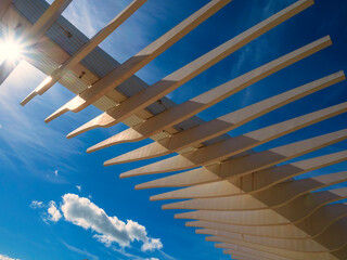 Estructura de una pergola de madera con cielo azul de fondo