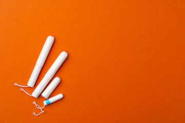 Medical female tampons on orange background top view