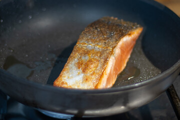 Baking a piece of salmon in a pan