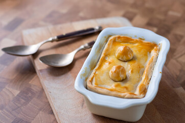 Tart or savory pie in a white dish at wooden table