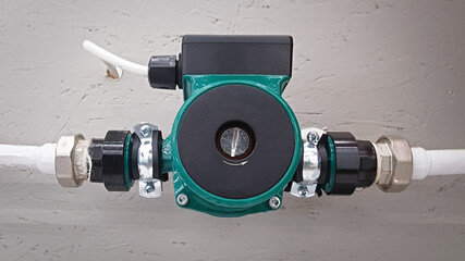 Green heating circulation pump mounted on a pipe