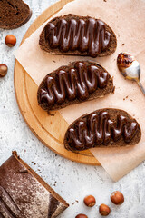 Toast made from rye bread and chocolate on a cutting board top view. Tasty sweet breakfast.