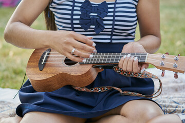 Close-up of a woman playing ukelele with a group of friends