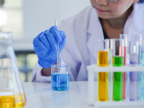 Senior scientists mixing solution in a beaker.