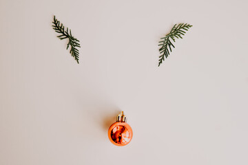 Creative and minimal christmas concept. Reindeer face made of Christmas decoration and pine branches on white background. Christmas season concept. Flat lay, top view.