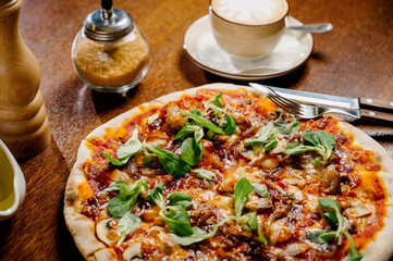 Mushroom pizza with addition mozzarella cheese and herbs on a wooden table, top view