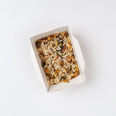 wild rice with spices, nuts and mushrooms in a cardboard plate. Food delivery
