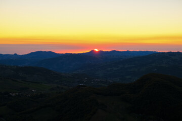 Red sun rising over the colorful sky and mountains landscape. Sunrise in mountains, Natural background. Italian Apennine