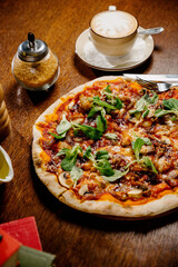 Mushroom pizza with addition mozzarella cheese and herbs on a wooden table, top view