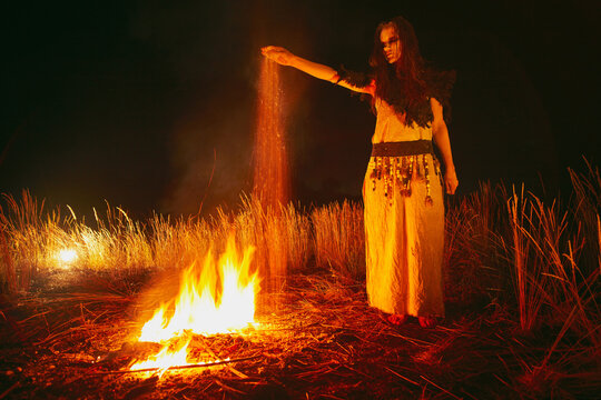 Woman in halloween witch costume throws the ashes of the dead.