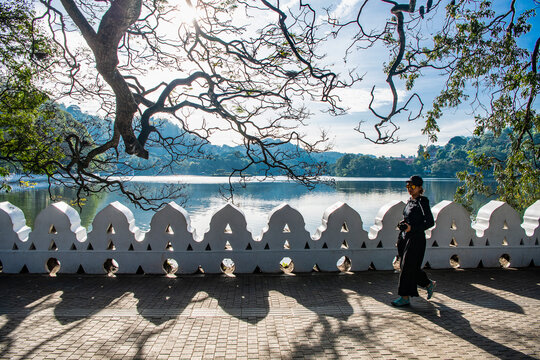 Woman walking along lake Kandy in Sri Lanka