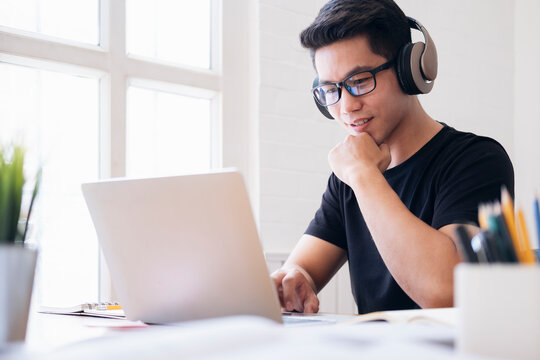Young collage student using computer and mobile device studying