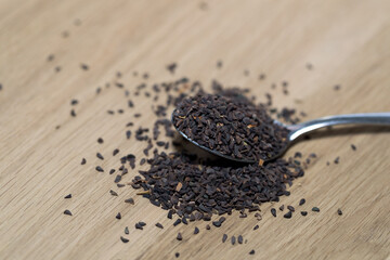 wild rue seeds, Peganum harmala in the spoon on a wooden table