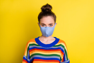 Portrait of brunette girl wear blue mask from corona rainbow sweater isolated on bright yellow color background