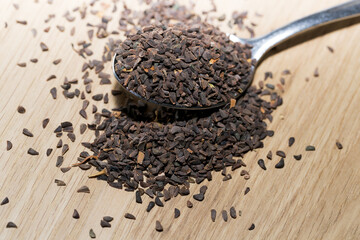 wild rue seeds, Peganum harmala in the spoon on a wooden table