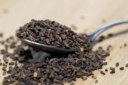 wild rue seeds, Peganum harmala in the spoon on a wooden table
