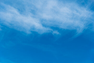 Clear blue sky with few white clouds in a zig zag pattern