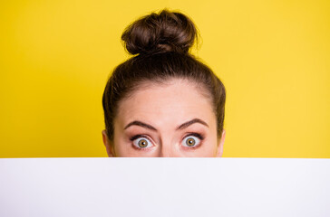 Photo of amazed young lady cover face look card board news proposition isolated on yellow color background